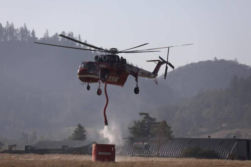A helicopter fills up with fire retardant from a tank off Franz Valley Road in Healdsburg on Wednesday, Oct. 30, 2019. (BETH SCHLANKER/ PD)