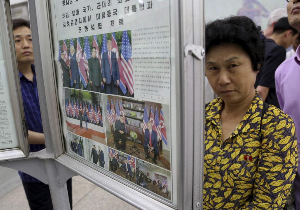 In this Wednesday, June 13, 2018, photo, people read a newspaper dominated with news on the summit between U.S. President Donald Trump and North Korean leader Kim Jong Un at a subway station in Pyongyang, North Korea. North Koreans are getting a new look at U.S. President Donald Trump now that his summit with leader Kim Jong Un is safely over and it's a far cry from the 'dotard' label Pyongyang slapped on him last year. (AP Photo/Dita Alangkara)
