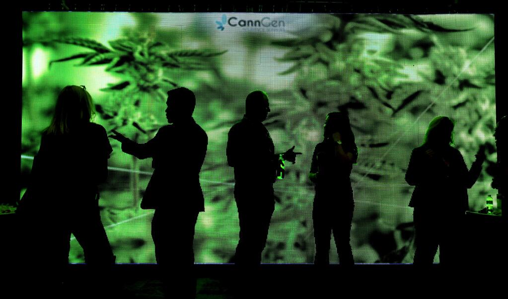 Agents with Venbrook Insurance Services of San Diego talk with potential customers in front over their CannaCon video board, Thursday April 20, 2017 at the Sonoma County Fairgrounds in Santa Rosa. (Kent Porter / The Press Democrat) 2017