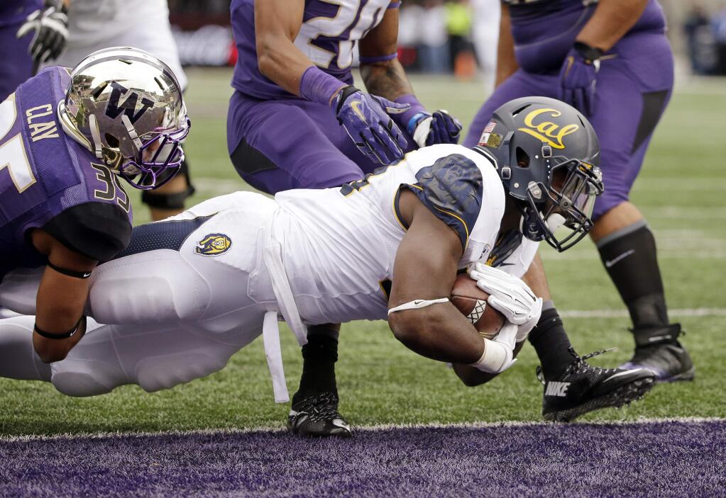 California running back Vic Enwere, right, pulls Washington's Brian Clay into the end zone on a touchdown in the first half Saturday, Sept. 26, 2015, in Seattle. (AP Photo/Elaine Thompson)