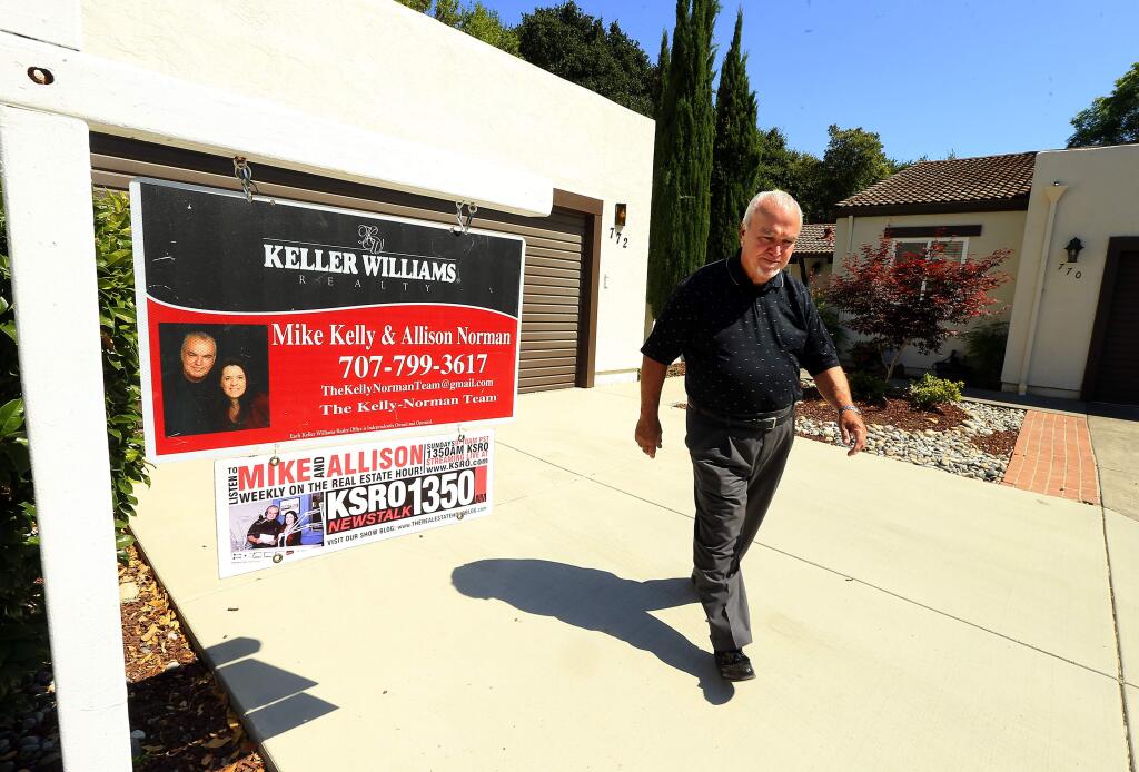 Keller Williams real estate agent Mike Kelly walks past a condo he is showing in the Brush Creek Villas in Santa Rosa. (JOHN BURGESS/The Press Democrat)