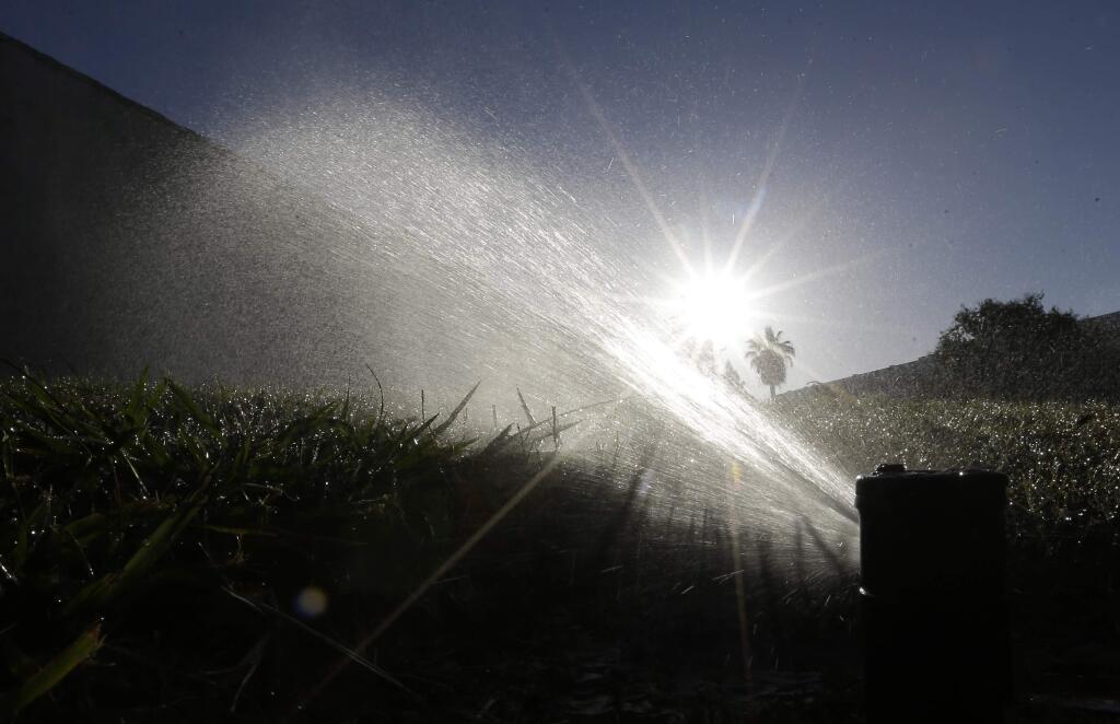 FILE - In this June 23, 2015, file photo a lawn is irrigated in Sacramento, Calif. (AP Photo/Rich Pedroncelli, File)