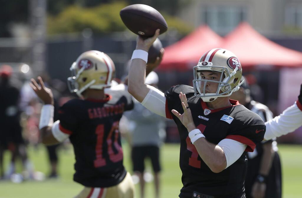 San Francisco 49ers quarterback Nick Mullens, right, throws a pass at the team's training camp in Santa Clara, Monday, July 29, 2019. (AP Photo/Jeff Chiu)
