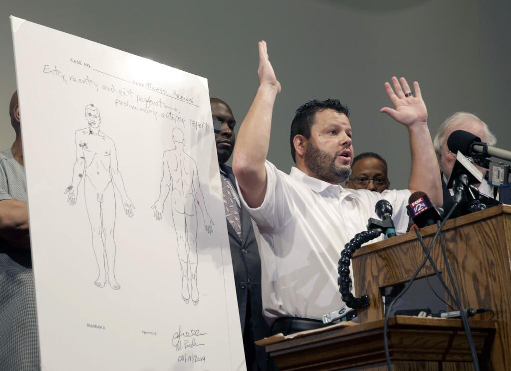 Forensic pathologist Shawn Parcells speaks during a news conference to share preliminary results of a second autopsy done on Michael Brown Monday, Aug. 18, 2014, in St. Louis County, Mo. The independent autopsy shows 18-year-old Michael Brown was shot at least six times, and Parcells, who assisted former New York City chief medical examiner Dr. Michael Baden during the autopsy, said a graze wound on Brown's right arm could have occurred in several ways. (AP Photo/Jeff Roberson)
