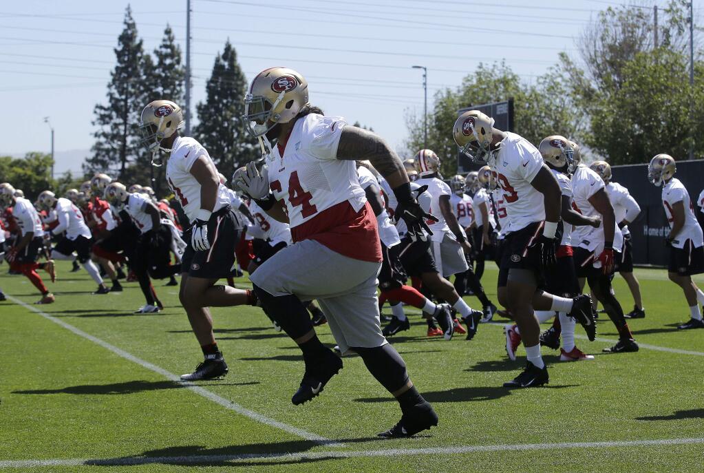 49ers' Mike Purcell, foreground, and teammates run during practice at the team's training facility in Santa Clara. (Jeff Chiu / Associated Press)