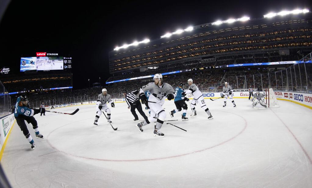 San Jose Sharks' Brent Burns, left, takes a shot against the Los Angeles Kings during the first period of a game Saturday, Feb. 21, 2015, in Santa Clara. (AP Photo/Tony Avelar)
