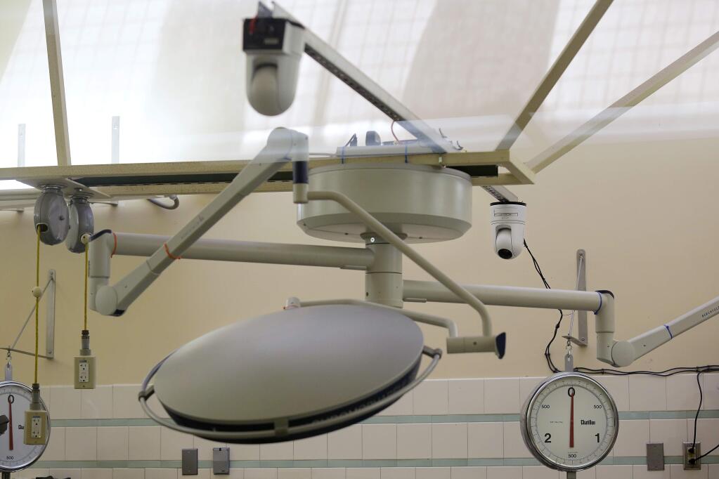 Cameras installed above the lights over the Sonoma County Coroner's operating theater allow detectives and investigators to watch autopsies in the next room in Santa Rosa on Thursday, August 7, 2014. (Conner Jay/The Press Democrat)