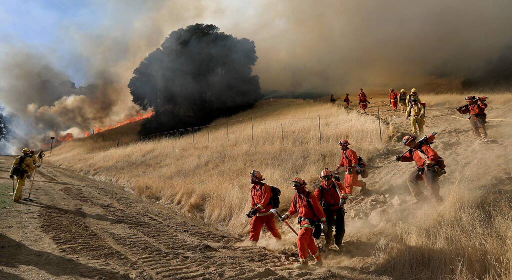Inmate firefighters evacuate off the fire line as a spot fire rips toward them during the Grape fire in Hopland, Tuesday Sept. 19, 2017. (Kent Porter / The Press Democrat) 2017