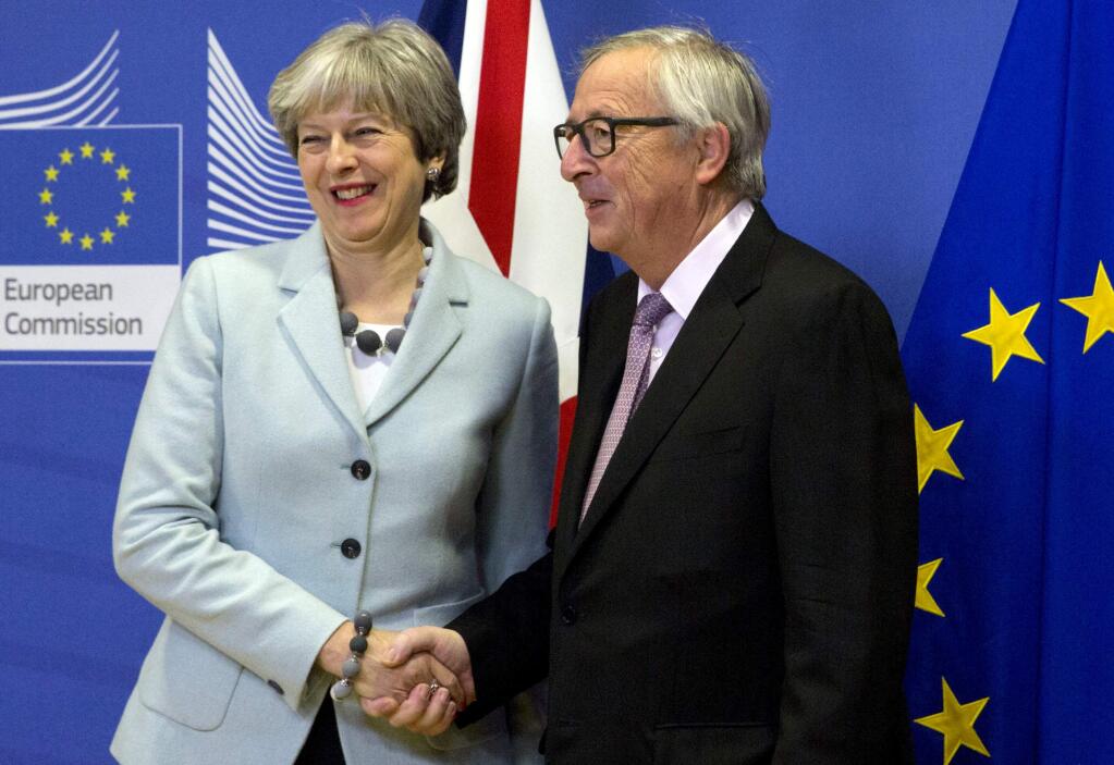 British Prime Minister Theresa May, left, is greeted by European Commission President Jean-Claude Juncker, right, prior to a meeting at EU headquarters in Brussels on Friday, Dec. 8, 2017. British Prime Minister Theresa May, met with European Commission President Jean-Claude Juncker early Friday morning following crucial overnight talks on the issue of the Irish border.(AP Photo/Virginia Mayo)