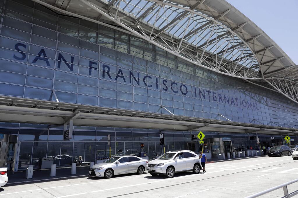 FILE - In this July 11, 2017 photo, vehicles wait outside the international terminal at San Francisco International Airport, in San Francisco. Federal officials are imposing new rules on nighttime landings at San Francisco airport after a close call. The FAA will also require 2 controllers in the tower. The changes come after an Air Canada jet narrowly missed planes on the ground before aborted an off-line landing on July 7. . (AP Photo/Marcio Jose Sanchez, File )
