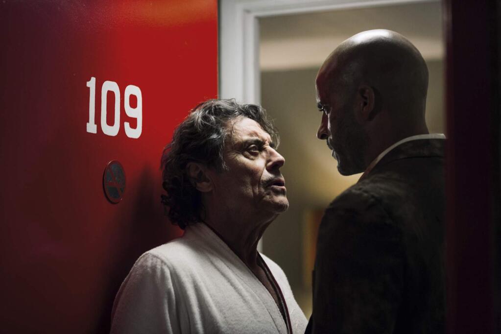 This image released by Starz shows Ian McShane, left, and Ricky Whittle in a scene from, 'American Gods.' A former convict is hired upon his release by a charismatic con man and finds himself in a hidden world where a battle brews between Old Gods and New Gods. (Jan Thijs/Starz via AP)