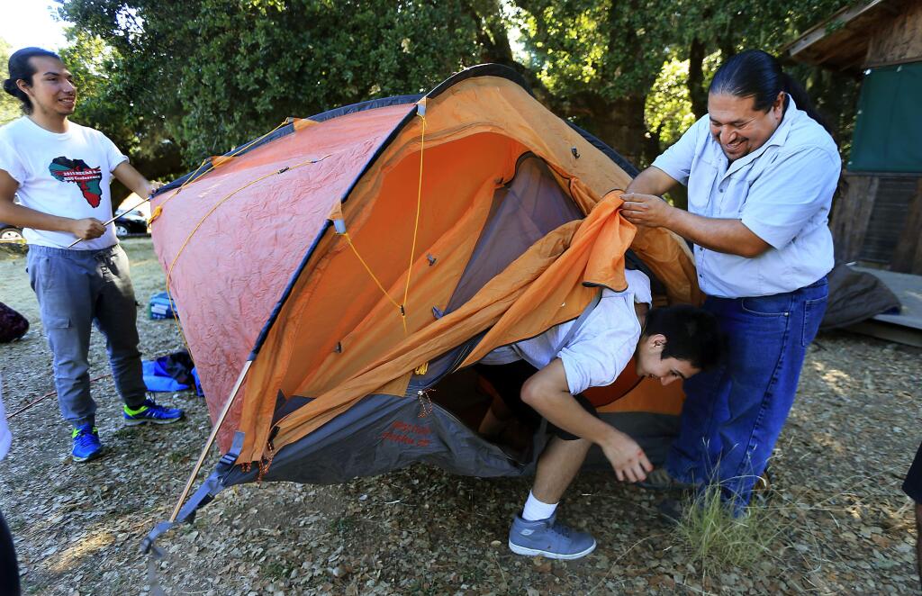 LandPaths Outreach and Diversity Director Omar Gallardo, right, holds the tent flap open for Christian Reyes while setting up camp with Enrique Farce Martinez, left, in the Inspired Forward program at the Bohemia Preserve in west Sonoma county. (JOHN BURGESS/The Press Democrat)