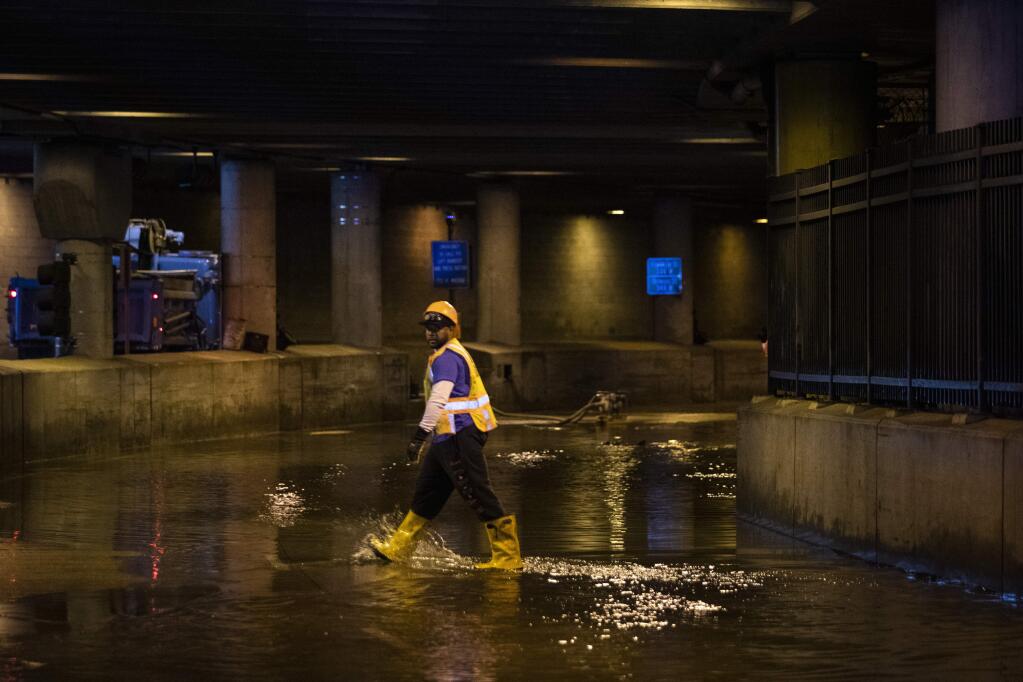 City workers remove water from Lower Wacker Drive near Randolph Street after overnight flooding, Monday, May 18, 2020 in Chicago. (Ashlee Rezin Garcia/Chicago Sun-Times via AP)