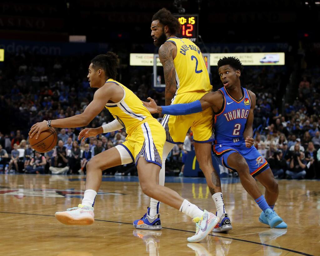 Golden State Warriors' Jordan Poole (3) drives the ball away from Oklahoma City Thunder's Shai Gilgeous-Alexander (2) while Willie Cauley-Stein (2) looks on during the first half of an NBA basketball game in Oklahoma City, Saturday, Nov. 9, 2019. (AP Photo/Garett Fisbeck)