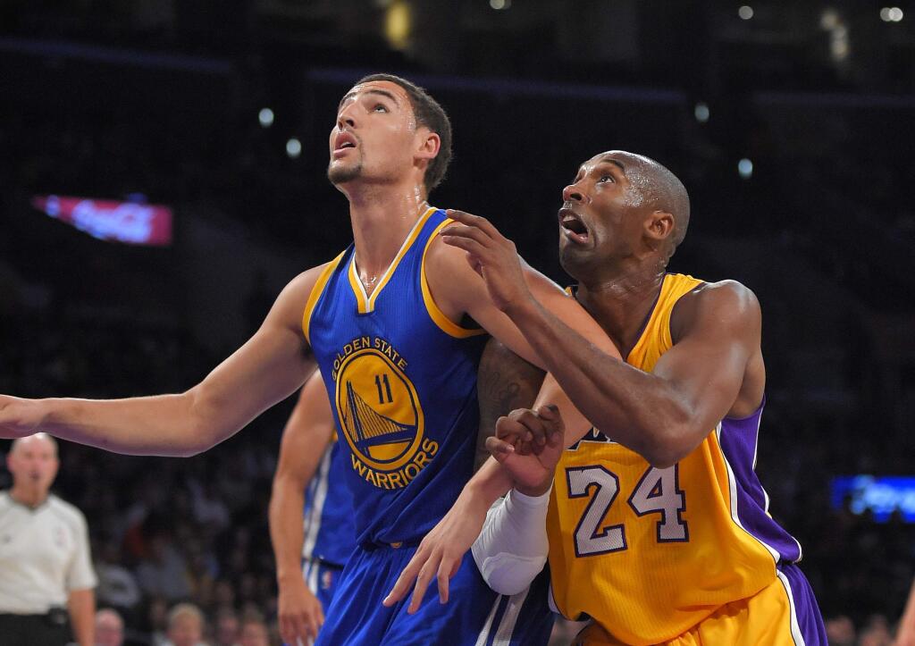 Golden State Warriors guard Klay Thompson, left, and Los Angeles Lakers guard Kobe Bryant battle for a rebound during the first half of a preseason basketball game, Thursday, Oct. 9, 2014, in Los Angeles. (AP Photo/Mark J. Terrill)