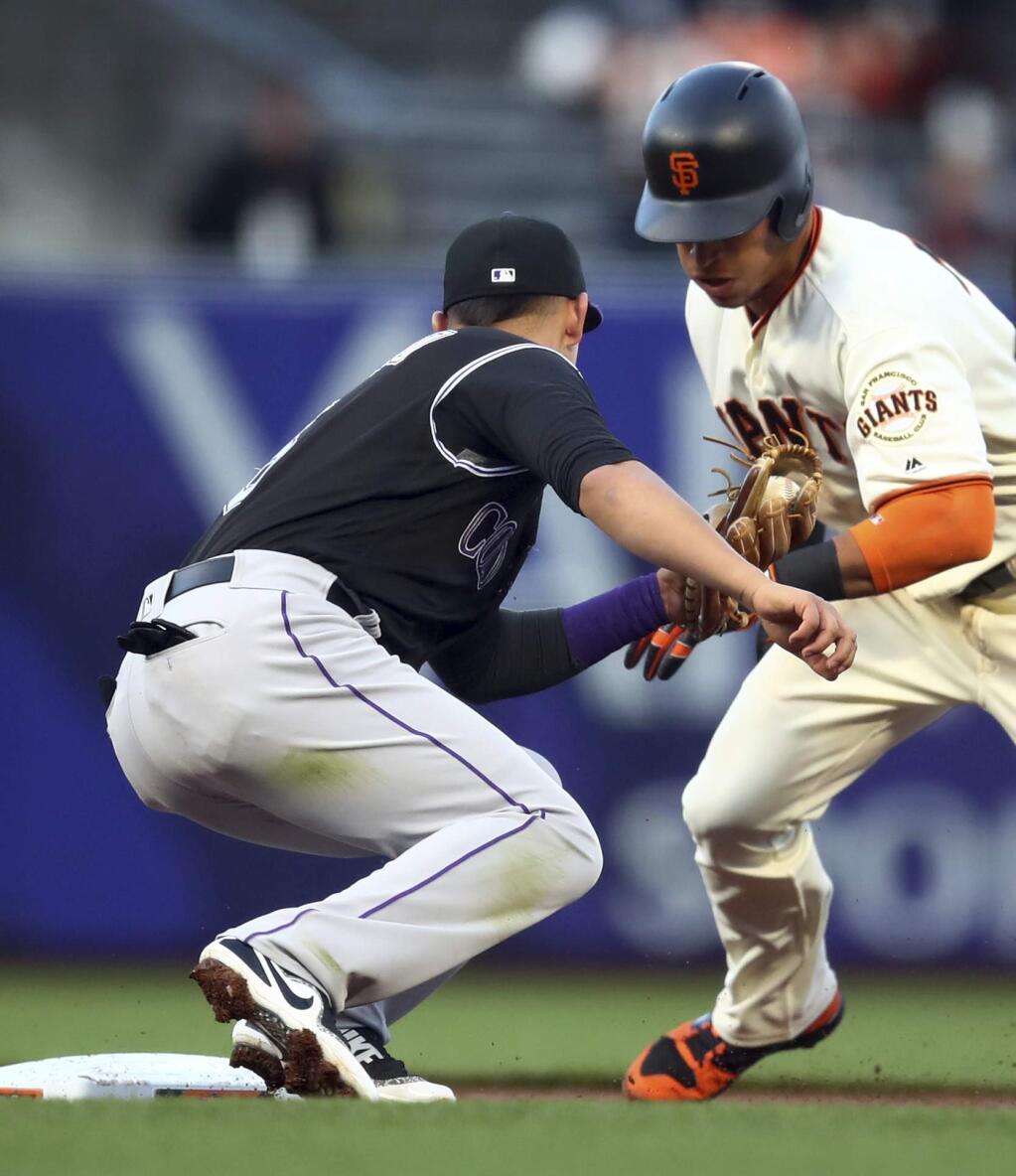 Colorado Rockies' Daniel Castro, left, tags out San Francisco Giants' Gorkys Hernandez on a first-inning attempted steal of second base during a baseball game Thursday, May 17, 2018, in San Francisco. (AP Photo/Ben Margot)