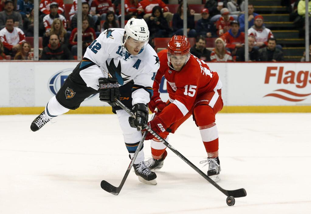 Detroit Red Wings center Riley Sheahan (15) defends San Jose Sharks center Patrick Marleau (12) during the first period of a game in Detroit on Thursday, March 26, 2015. (AP Photo/Paul Sancya)
