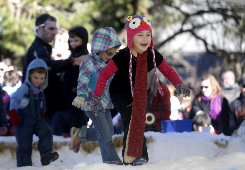 After waiting in a long line, Liliana Simpson, 5, runs to play in the snow during the Snow Days event at the Children's Museum of Sonoma County in Santa Rosa, on Saturday, January 14, 2017. (BETH SCHLANKER/ The Press Democrat)