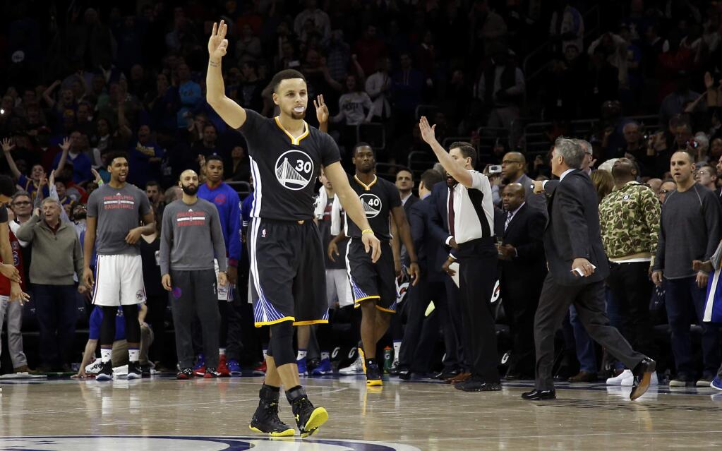 Golden State Warriors' Stephen Curry (30) celebrates after Harrison Barnes (40) made the go-ahead 3-point basket in the last seconds of an NBA basketball game against the Philadelphia 76ers, Saturday, Jan. 30, 2016, in Philadelphia. Golden State won 108-105. (AP Photo/Matt Slocum)