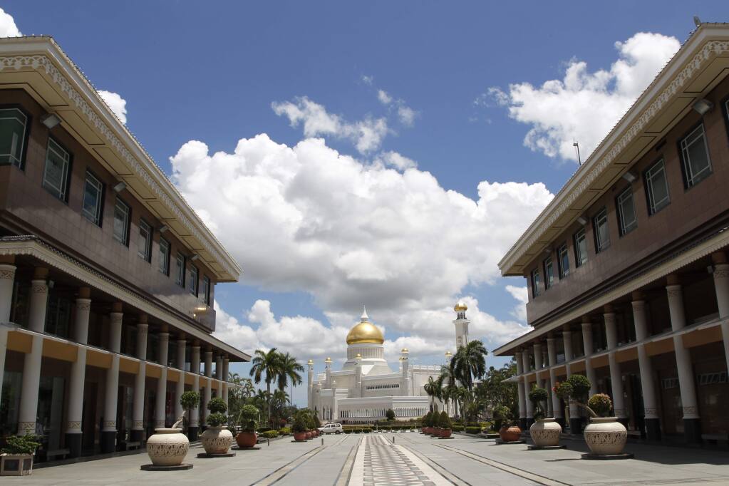 In this April 23, 2013, photo, Sultan Omar Ali Saifuddien Mosque, one of the landmarks of Bandar Seri Begawan in Brunei. Brunei announced to implement Islamic criminal laws that punishes gay sex by stoning offenders to death. The legal change in the tiny, oil-rich monarchy, which also includes amputation for theft, is due to come into force Wednesday, April 3, 2019. (AP Photo/Vincent Thian)