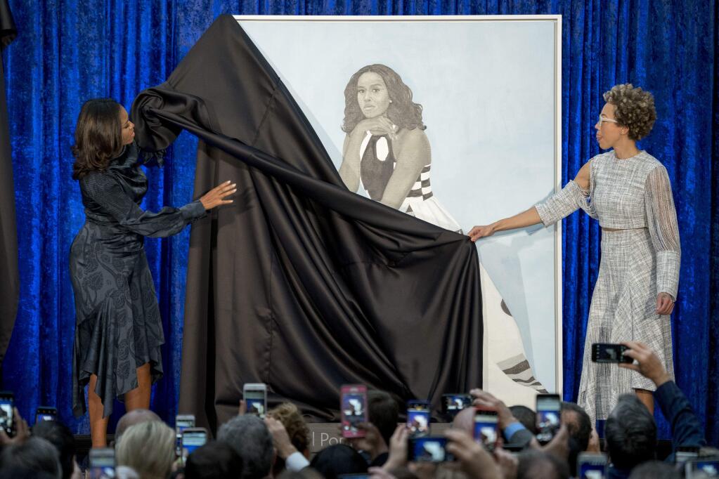 Former first lady Michelle Obama and Artist Amy Sherald, right, unveil Michelle Obama's official portrait at the Smithsonian's National Portrait Gallery, Monday, Feb. 12, 2018, in Washington. (AP Photo/Andrew Harnik)