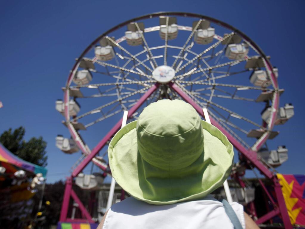 Teresa Purroy watches as her great grandchildren ride the Ferris wheel on the last day of the Sonoma County Fair in Santa Rosa in 2012. (BETH SCHLANKER/ PD FILE)