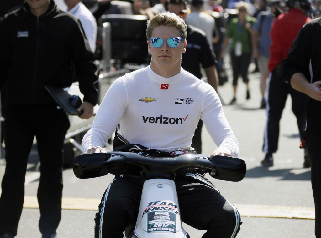 Josef Newgarden rides a scooter to his car for a warmup before an IndyCar auto race Sunday, Sept. 17, 2017, in Sonoma, Calif. (AP Photo/Eric Risberg)