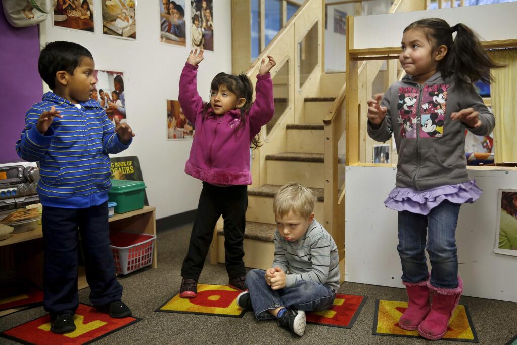 Greysen Giarrita, 4, sits down after not wanting to dance with his preschool classmates David Castaneda, 4, Ruby River, 3, center, and Kaily Lopez, 4, during circle time at El Verano Elementary School on Thursday, December 3, 2015 in Sonoma, California . (BETH SCHLANKER/ The Press Democrat)