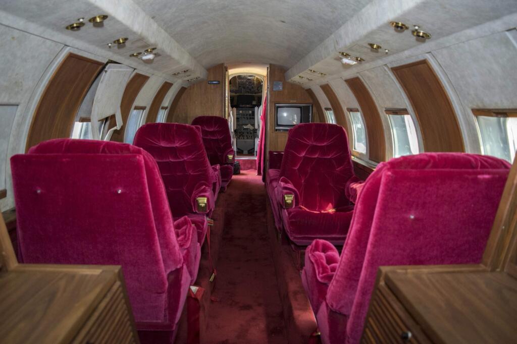 This undated photo provided by GWS Auctions, Inc. shows the interior of a private jet once owned by Elvis Presley on a runway in New Mexico. GWS Auctions Inc. out of California is holding an auction for the plane on May 27, 2017 at an event featuring A-list celebrity memorabilia. The interior was designed by Elvis Presley, with gold-tone, woodwork, inlay and red velvet seats and red shag carpet. However, the plane has no engine and the cockpit has not been restored. (GWS Auctions, Inc. via AP)