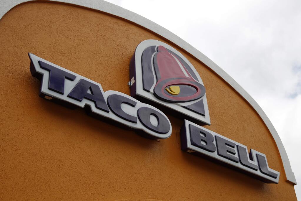 FILE - This Friday, May 23, 2014, file photo shows a sign at a Taco Bell in Mount Lebanon, Pa. Taco Bell and Pizza Hut say they're getting rid of artificial colors and flavors, making them the latest big food companies scrambling to distance themselves from ingredients people might find unappetizing. (AP Photo/Gene J. Puskar, File)