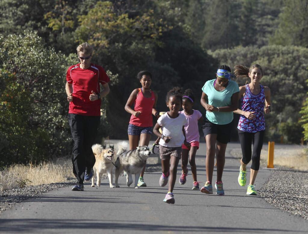 Ryan Hall, from left, runs with his girls Mia, 13, Lily, 5, Jasmine, 8, and Hana, 15, and his wife Sara in 2015 in Redding. (Greg Barnette / For The Press Democrat)