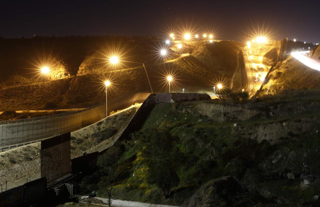 Floodlights from the U.S. illuminate multiple border walls, seen Monday from Tijuana, Mexico. President Donald Trump argued his case to the nation Tuesday that a “crisis” at the U.S.-Mexico border requires a wall he's demanding before ending the partial government shutdown. (GREGORY BULL / Associated Press)