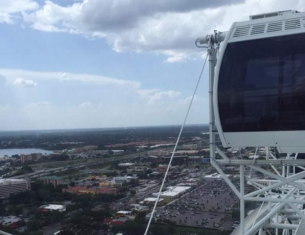 In this photo provided by Makayla Bell, the Ferris wheel known as the Orlando Eye is stopped Friday, July 3, 2015, in Orlando, Fla. Authorities say the 400-foot Ferris wheel stopped moving for more than 45 minutes, stranding riders aboard. (Makayla Bell via AP)