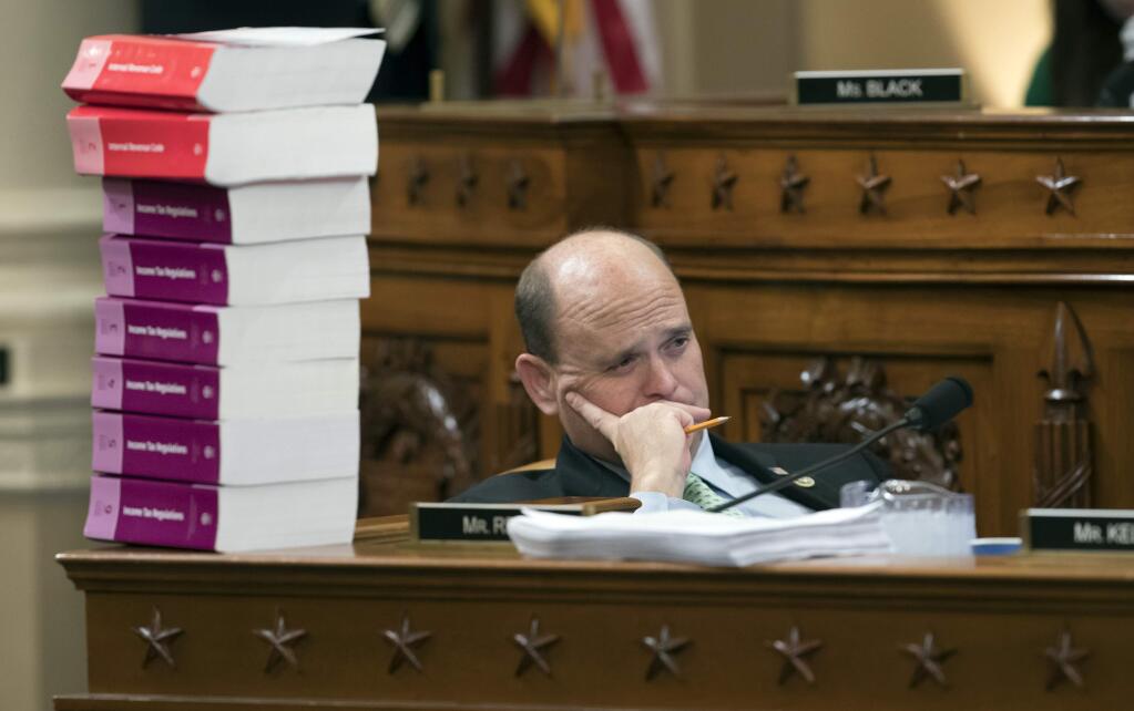 Rep. Tom Reed, R-N.Y., listens as he sits next to a stack of IRS Code volumes as the House Ways and Means Committee begins the markup process of the GOP's far-reaching tax overhaul, on Capitol Hill in Washington, Monday, Nov. 6, 2017. (AP Photo/J. Scott Applewhite)