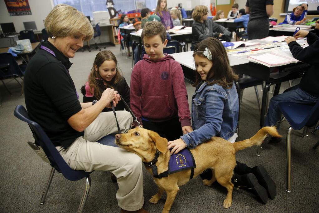 Photos by Beth Schlanker / The Press DemocratMary Ann Weber and her dog, Nui, meet with third-grade students Lyla Niehage, 9, Will Pratt, 9, and Jordan Espinosa, 8, on Jan. 8 as part of the Paws As Loving Support program at Riebli Elementary School in Santa Rosa. Below, Soham Pravin, 9, right, Dylan Whittemore, 10, center, and James Keating 10, spend time with Nui.