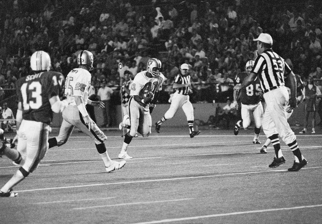 Warren Wells (81) carries to complete a 36-yard touchdown in the last minute of a game against Miami at the Orange Bowl on Saturday, Oct. 3, 1970. Also shown are Fred Biletnikoff (25) and Jake Scott (13). (AP Photo)