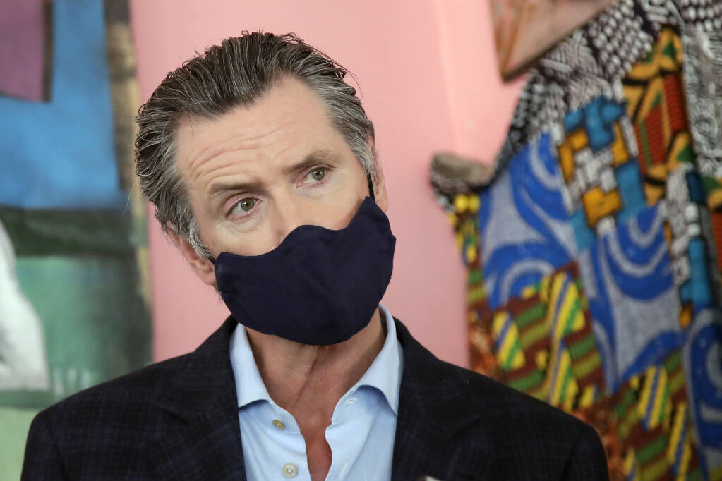 FILE - In this June 9, 2020, file photo, California Gov. Gavin Newsom wears a protective mask on his face while speaking to reporters at Miss Ollie's restaurant during the coronavirus outbreak in Oakland, Calif. Newsom has had a summer of muddled messaging and bad news in the coronavirus fight, a trend crystallized by the governor's delayed response to a data error that caused a backlog of nearly 300,000 virus test results. (AP Photo/Jeff Chiu, Pool, File)