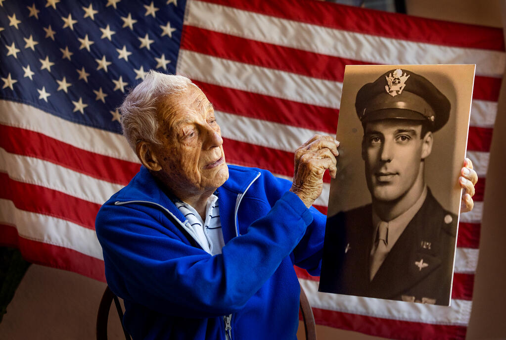 WWII navigator Al Maggini, 107, with a photo of himself from the war in his Oakmont home, Thursday, November 3, 2022. Maggini flew 35 combat missions over Germany in a B-17 bomber.  (John Burgess/Press Democrat)
