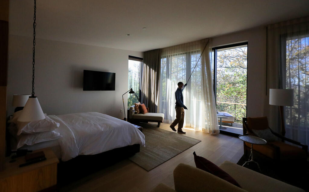 Quinn Reedy, guest services associate at Montage Healdsburg, opens the curtains of a deluxe studio room at the new luxury resort on the city’s northern edge. (Christopher Chung / The Press Democrat) 2020