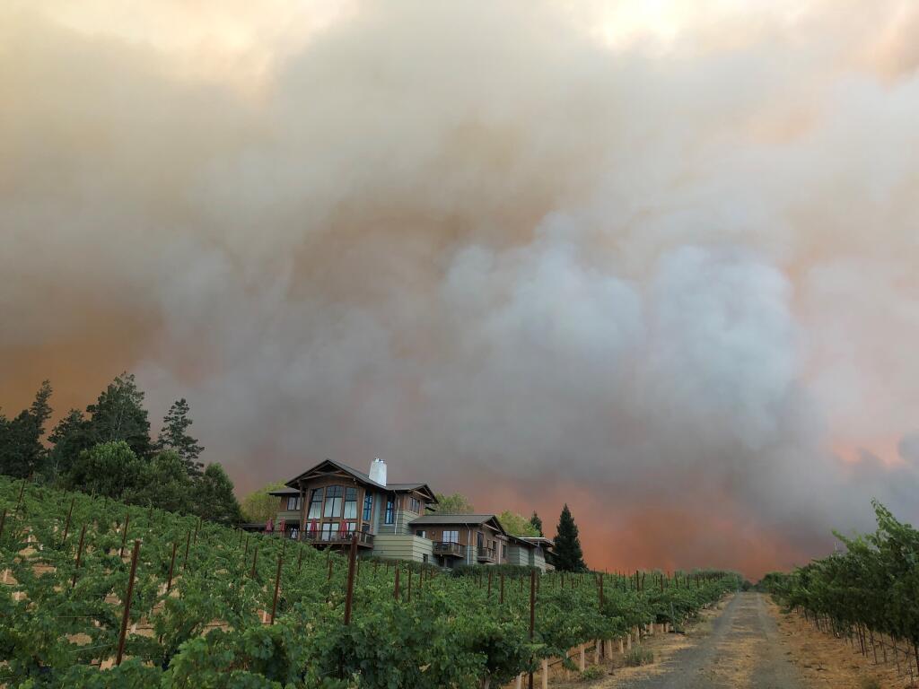 A home on West Dry Creek Road is framed by smoke and the glow of the Walbridge fire on Thursday, Aug. 20, 2020. (Beth Schlanker / The Press Democrat)