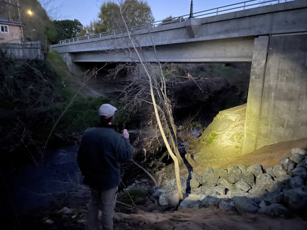 Francisco Kilgore, associate director of Sonoma Overnight Support, shines a flashlight under Sonoma Creek bridge at Boyes Hot Springs while conducting a census for Point-In-Time's homeless count. (Chase Hunter/Index-Tribune)