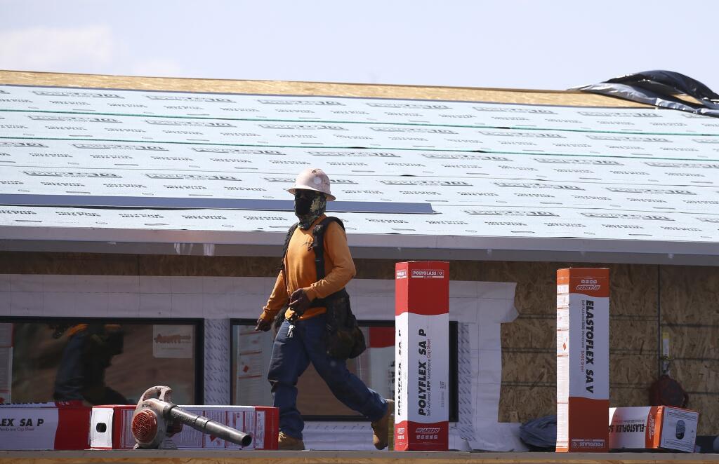 FILE - A construction worker continues building at a large housing development, April 21, 2020, in Phoenix. Arizona will not approve new housing construction on the fast-growing edges of metro Phoenix that rely on groundwater thanks to years of overuse and a multi-decade drought that is dwindling its water supply. In a news conference Thursday, June 1, 2023, Gov. Katie Hobbs announced the pause on new construction that would affect some of the fastest-growing areas of the nation's 5th largest city. (AP Photo/Ross D. Franklin, File)