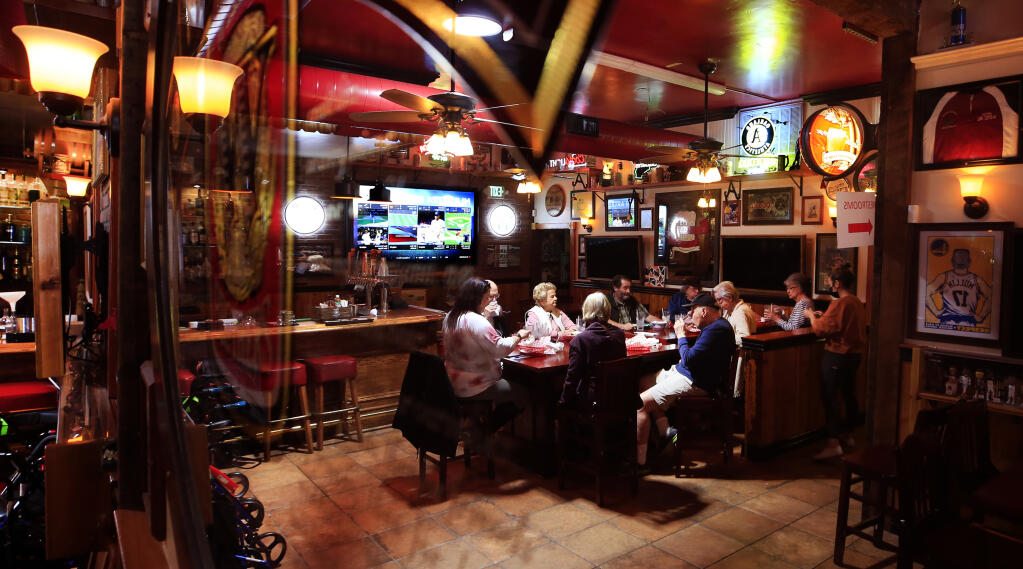 Reflected in a mirror at Ausiello's 5th Street Bar and Grill in Santa Rosa, a group of seniors from Oakmont Gardens, fully vaccinated, take their first trip to a restaurant, Wednesday, April 7, 2021 since the beginning of the shutdown due to COVID. (Kent Porter / The Press Democrat) 2021
