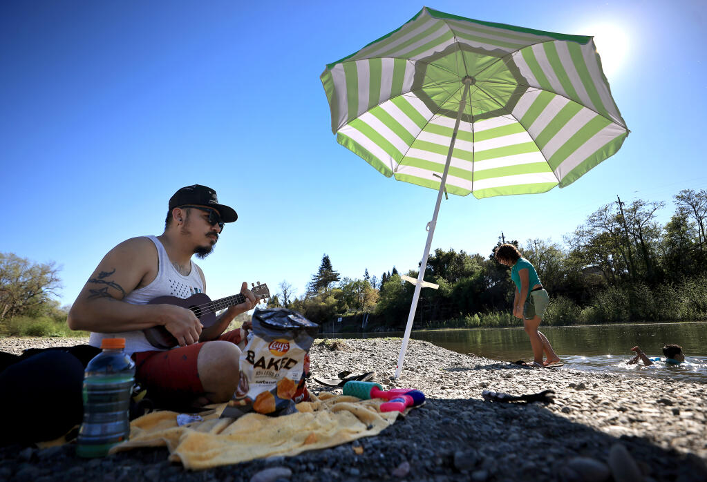 During the first full week of spring, summer-like temperatures Tuesday prompted Jairo Mendez and his children Heiley, middle, and Jose Luis to hit Healdsburg Veterans Memorial Beach. (Kent Porter / The Press Democrat)