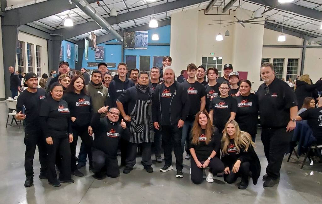 Celebrity chef and TV personality Guy Fieri poses with volunteers at a dinner for the Sonoma County Sheriff’s Office in a photo posted Saturday, Dec. 18, 2021, by the Guy Fieri Foundation. (Guy Fieri Foundation / Twitter)
