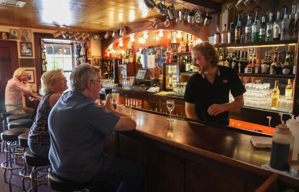 The Swiss Hotel bartender Kole Morgan, right, serves Jim Worthington and Linda Miller in the historic bar in Sonoma on Wednesday, August 3, 2022.  (Christopher Chung/The Press Democrat)