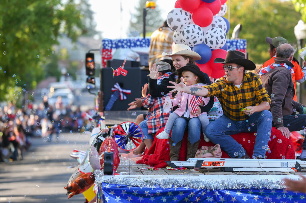 Conner and Nicole Campbell, with their daughter Evelyn, toss candy from a float during the Twilight Parade in Healdsburg on Thursday, May 25, 2023.  (Christopher Chung/The Press Democrat)