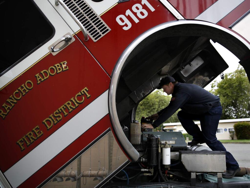 Fire engineer James Deurloo replaces fluids in the engine of a fire truck at the Rancho Adobe Fire Protection District's station in Cotati in 2014. (BETH SCHLANKER/ PD FILE)