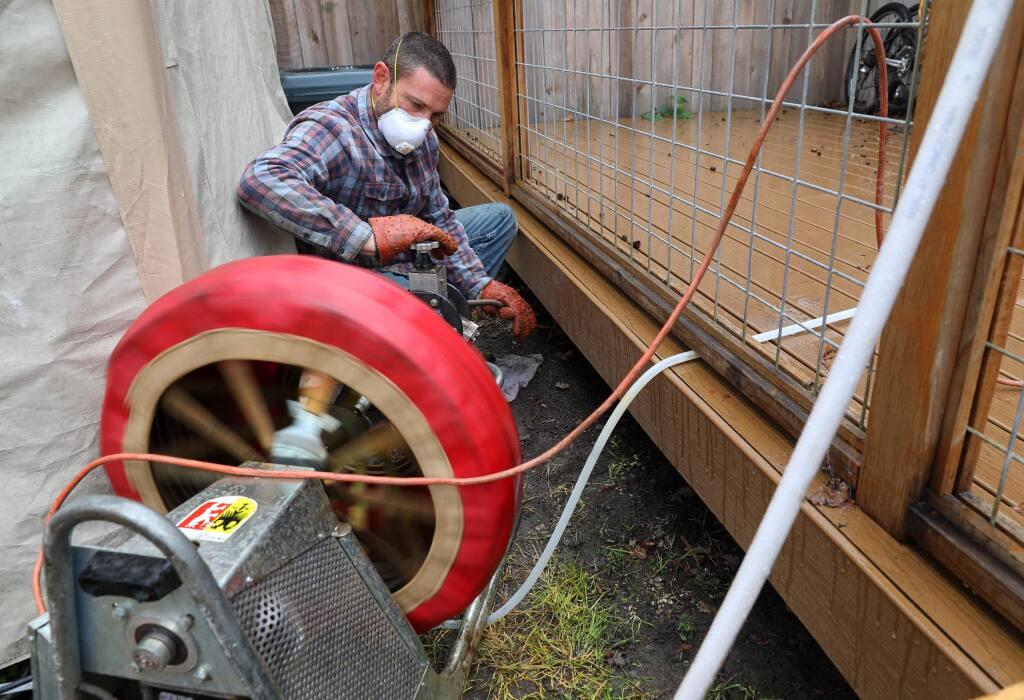 Greg Fremault, of Redwood Sewer and Drain, uses a snake to root out a sewer line at a residence in Santa Rosa on Monday, April 6, 2020. (Christopher Chung/ The Press Democrat)