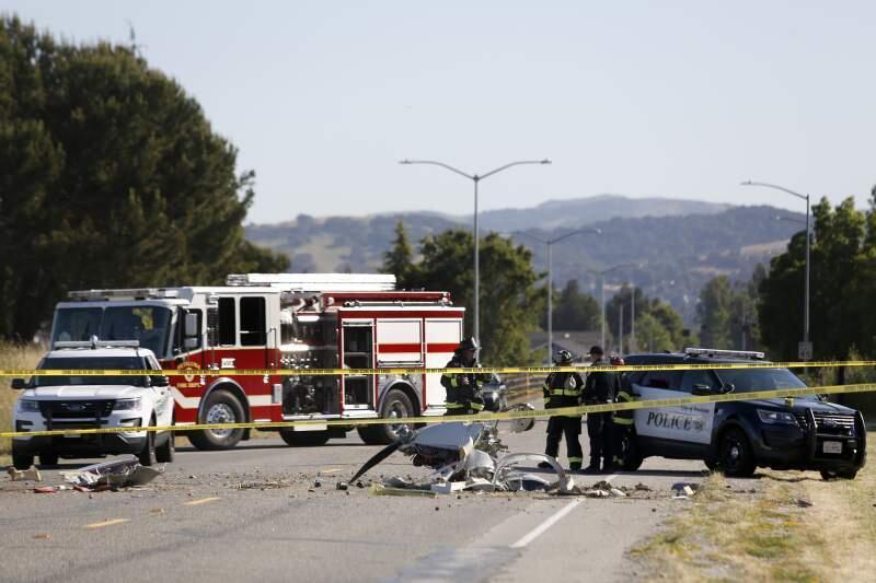 Petaluma firefighers and police work at the scene of a single-engine plane crash in which two people were killed on E. Washinton Street near the Petaluma Municipal Airport Sunday. (BETH SCHLANKER/The Press Democrat)